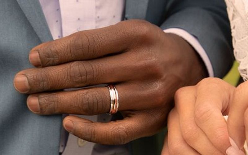 Man's hand with gold wedding band